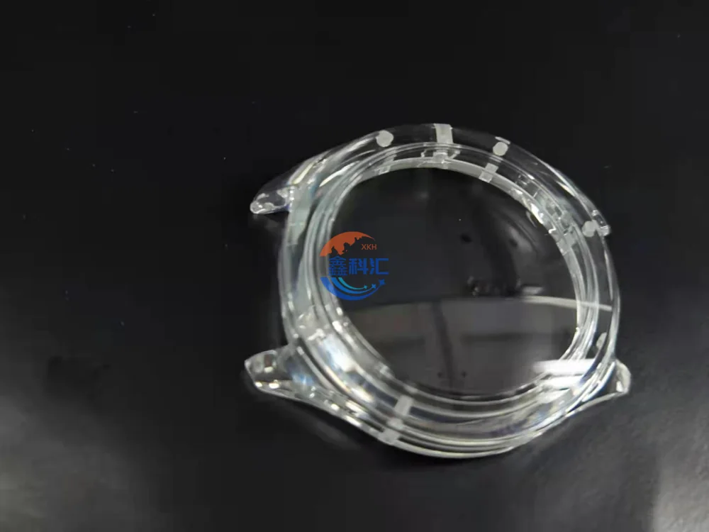 Round transparent sapphire watch case on a dark inspection background